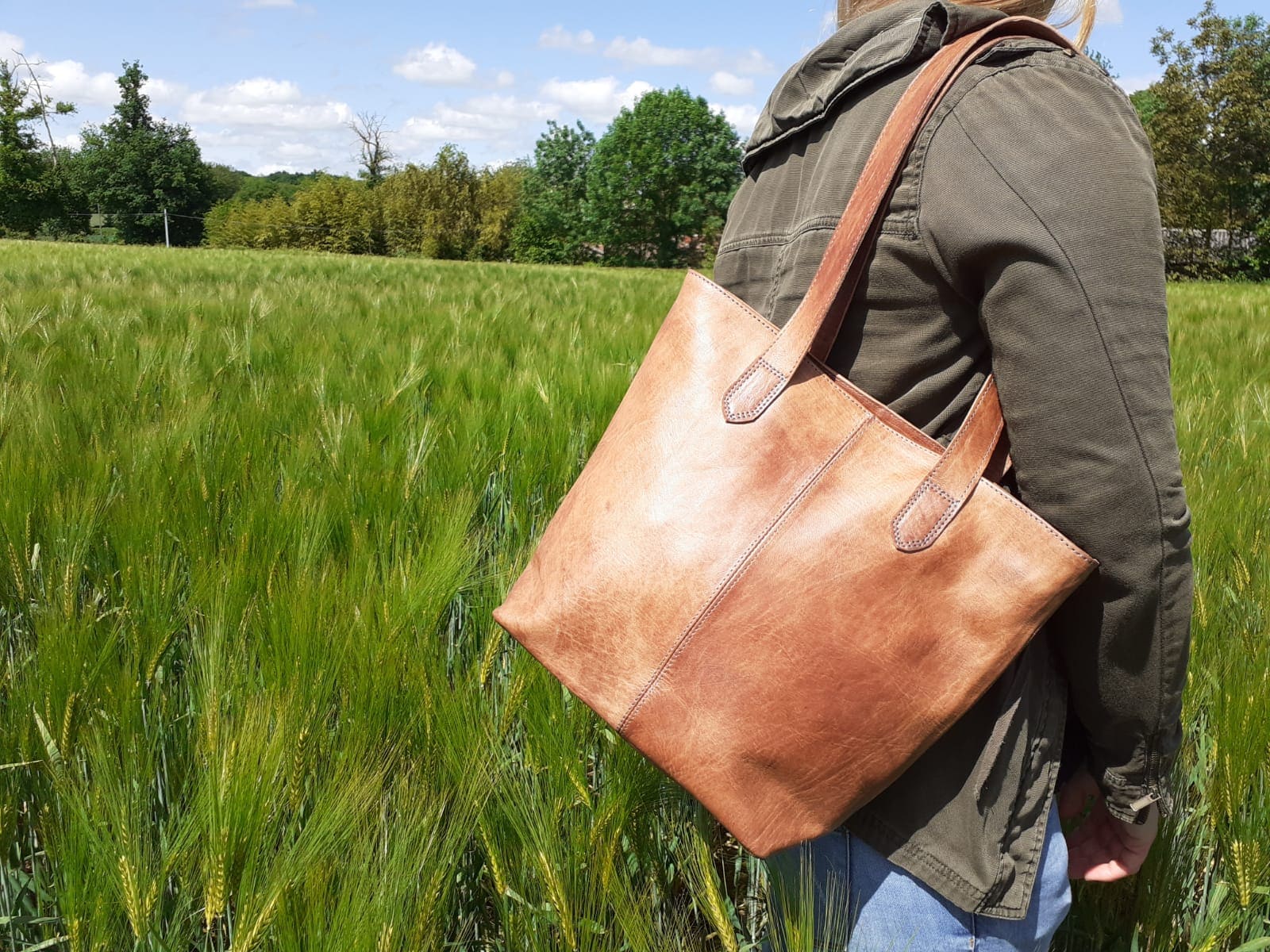 cabas en cuir clair porté épaule par une femme