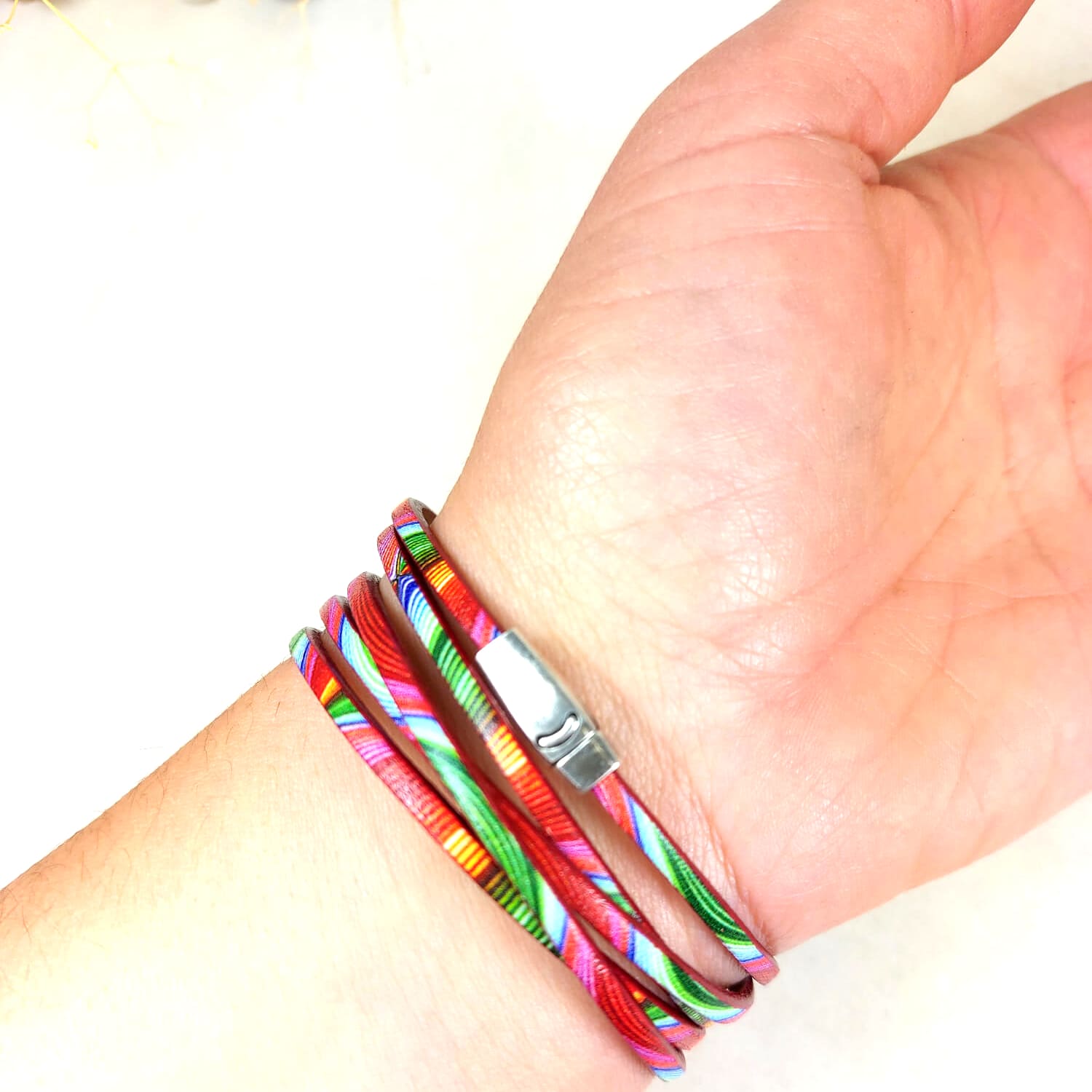 bracelet multicolore rose vert orange porté au poignet 5 lanières fermoir argenté