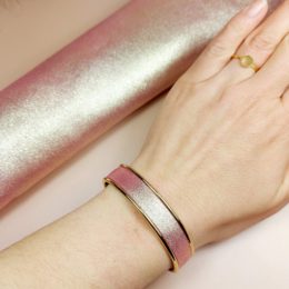 bracelet jonc doré à l'or fin avec cuir rose doré pailleté sur poignet de femme