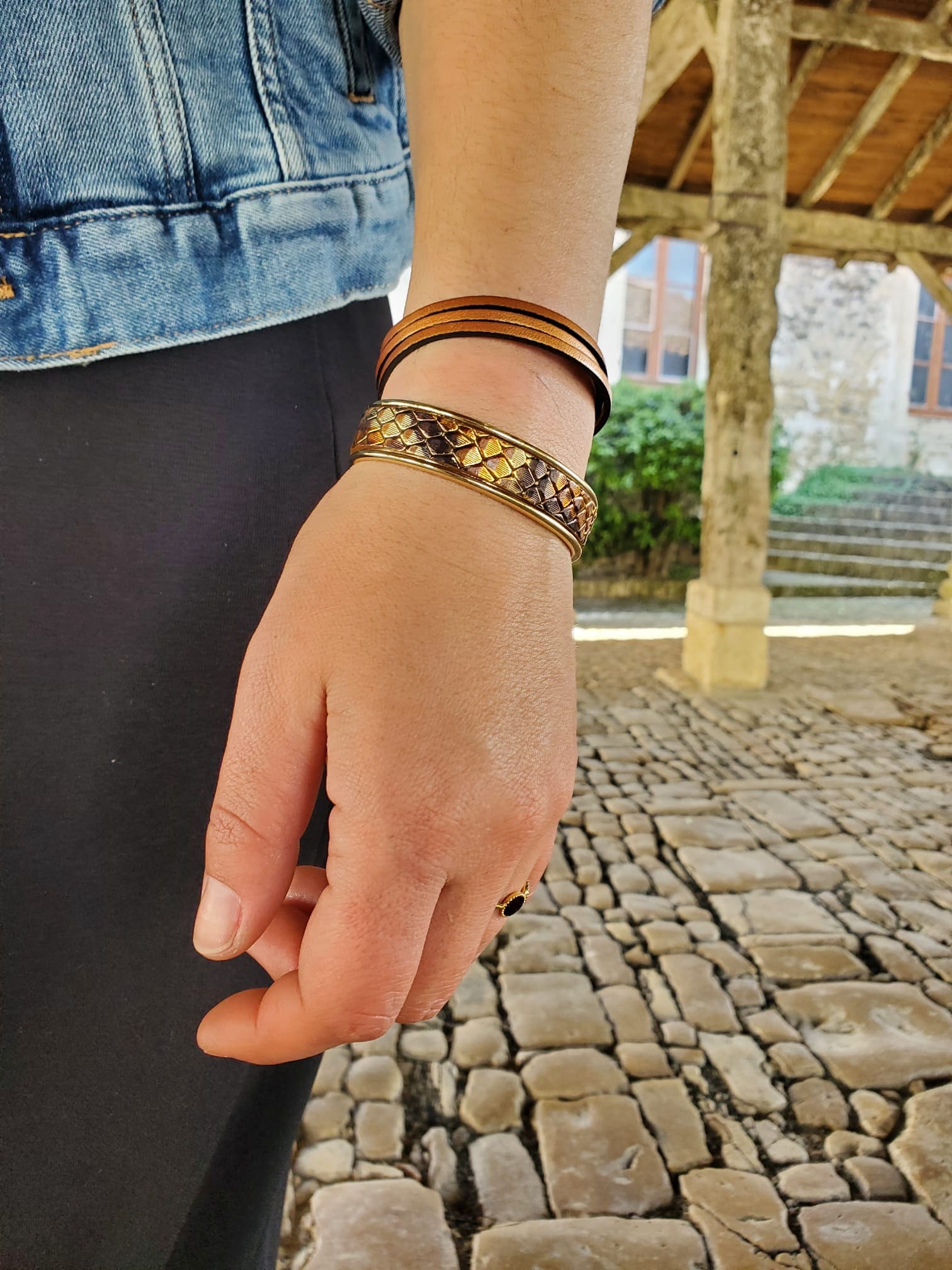 bracelets jonc imitation serpent et bracelet multirang beige portés au poignet d'une femme